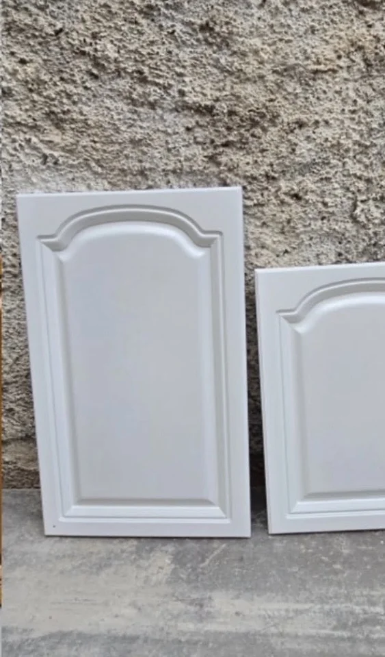 White raised panel cabinet door with a smooth painted finish shown beside part of a matching door