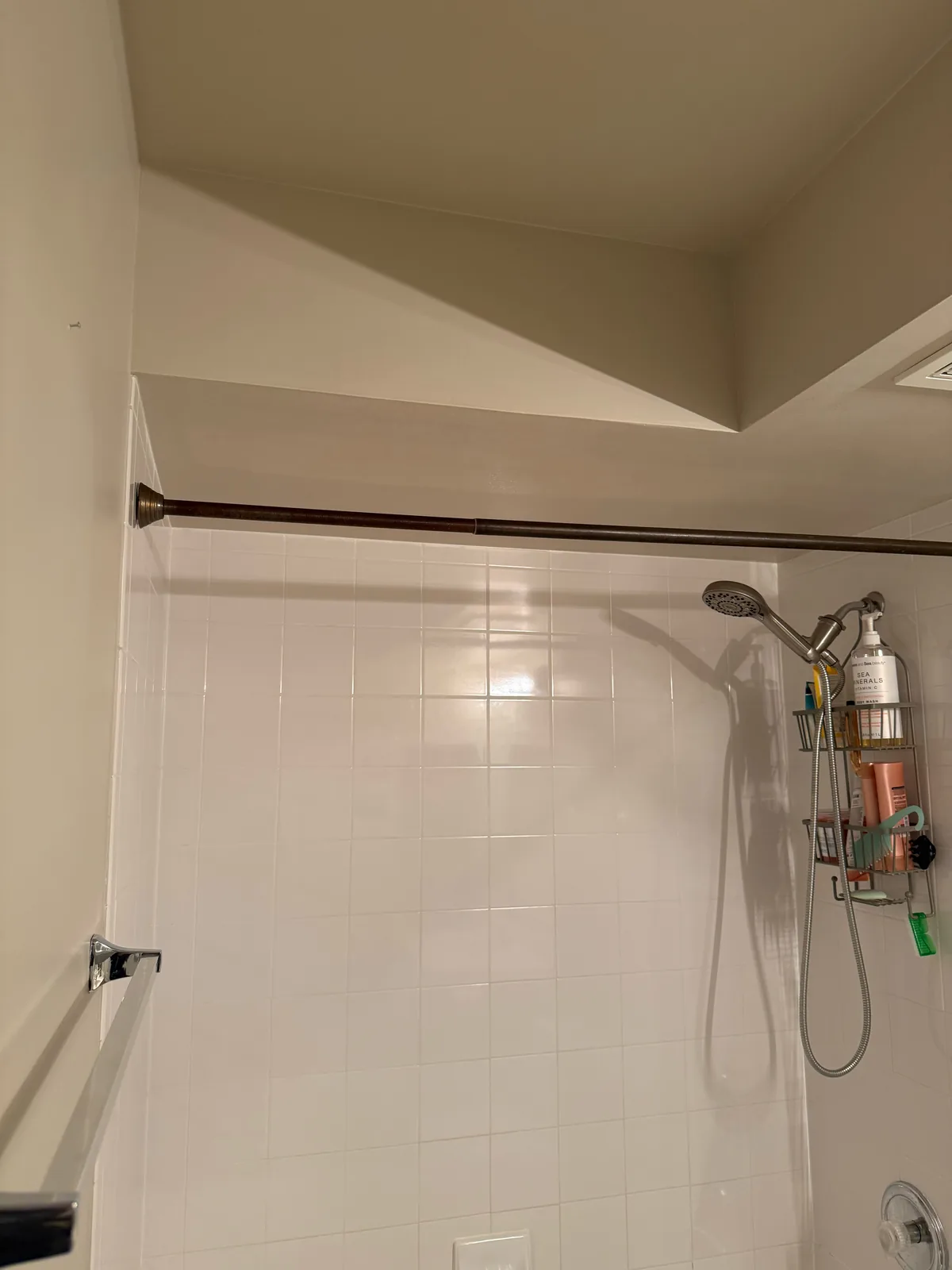 After drywall repair, showing the finished bathroom wall and ceiling area above the shower