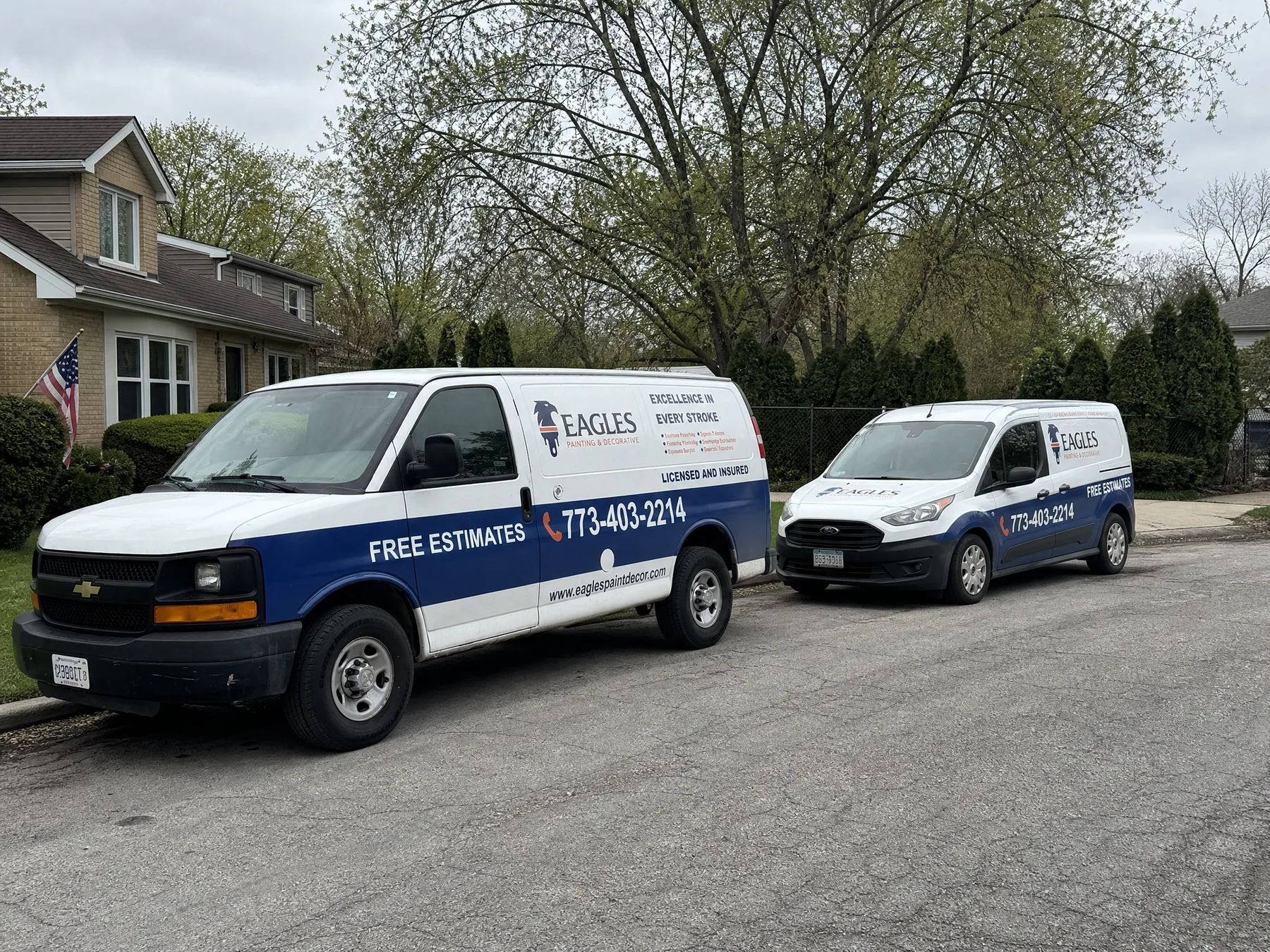 Eagles Painting and Decorative branded field vehicles beside a residential project