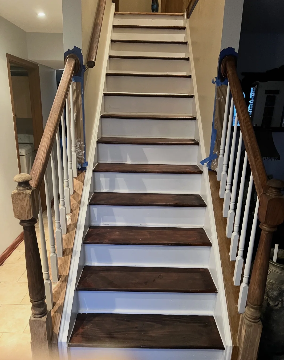 After interior painting, showing crisp white stair risers and trim surrounding existing dark stained stair treads and handrails