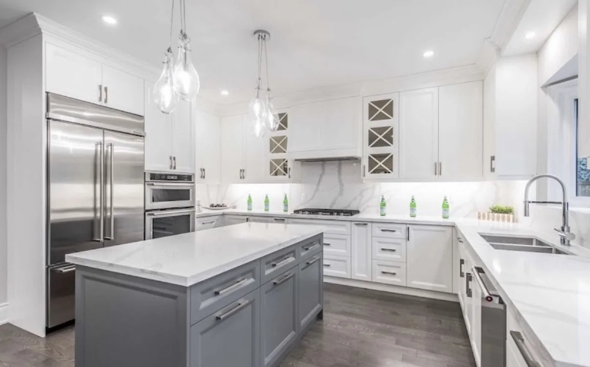Bright modern kitchen with white cabinetry, a gray island, stainless-steel appliances, and pendant lights