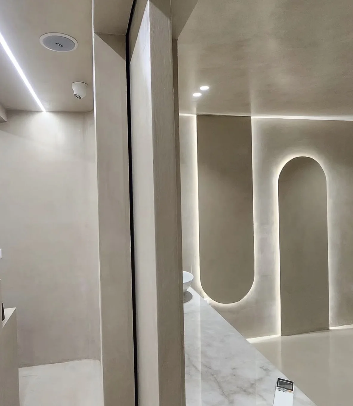Architectural wall with a continuous gray microcement finish