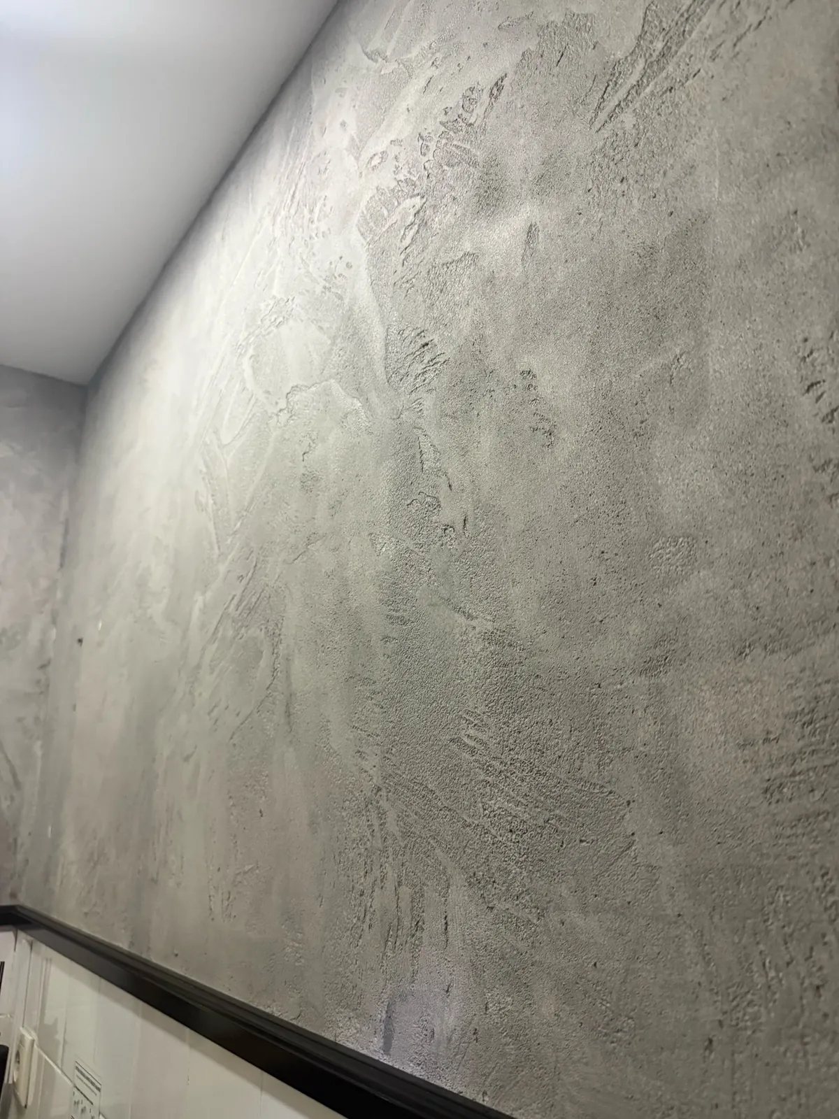 Close architectural view of pale gray Venetian plaster with layered irregular trowel movement