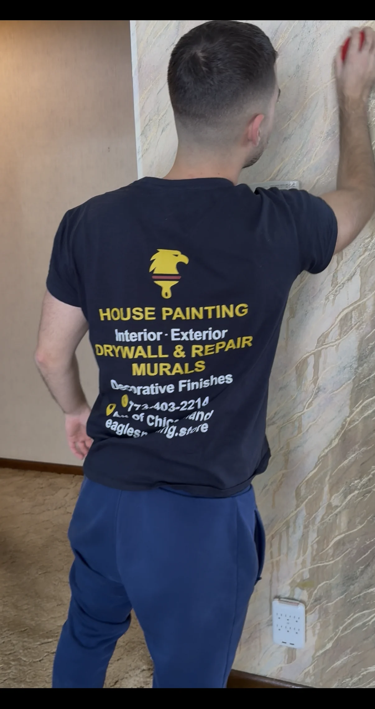 Eagles painter smoothing a stripped wall surface during wallpaper removal preparation
